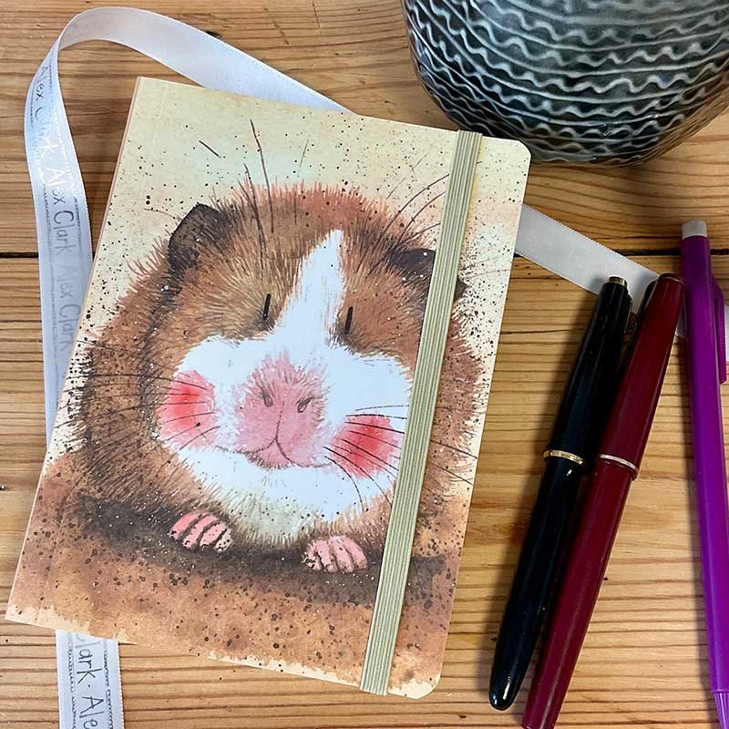 Alex Clark Gilbert Guinea Pig Small Chunky Notebook on a wooden table