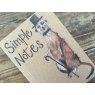 Alex Clark Meerkat Small Kraft Notebook close up of front cover on a wooden table