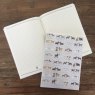 Alex Clark Delightful Dogs Large Soft Notebook opened on a wooden table