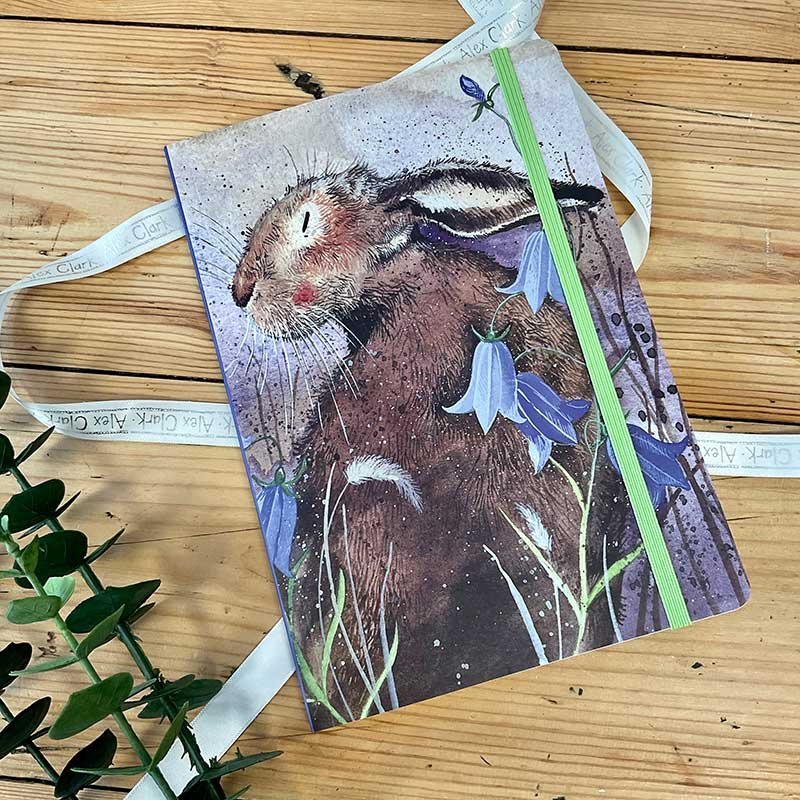 Alex Clark Hare Large Chunky Notebook front cover on a wooden table