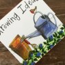 Alex Clark Growing Ideas Watering Can Mini Magnetic Notepad close up of front on a wooden table