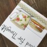 Alex Clark Food For Thought Tea & Cake Mini Magnetic Notepad close up of front on a wooden table