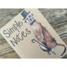 Alex Clark Meerkat Small Kraft Notebook close up of front cover on a wooden table