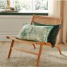 Graham & Brown Coppice Forest Sage Feather Cushion lifestyle image of the cushion on a chair