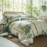 Graham & Brown Coppice Forest Sage Feather Cushion lifetyle image of the cushion on a bed
