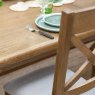 Manor Oak 2m Extending Crossed Leg Dining Table With 5 Cross Back Chairs & Bench close up lifestyle image