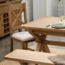 Manor Oak 2m Extending Crossed Leg Dining Table With 4 Cross Back Chairs & Bench close up lifestyle image